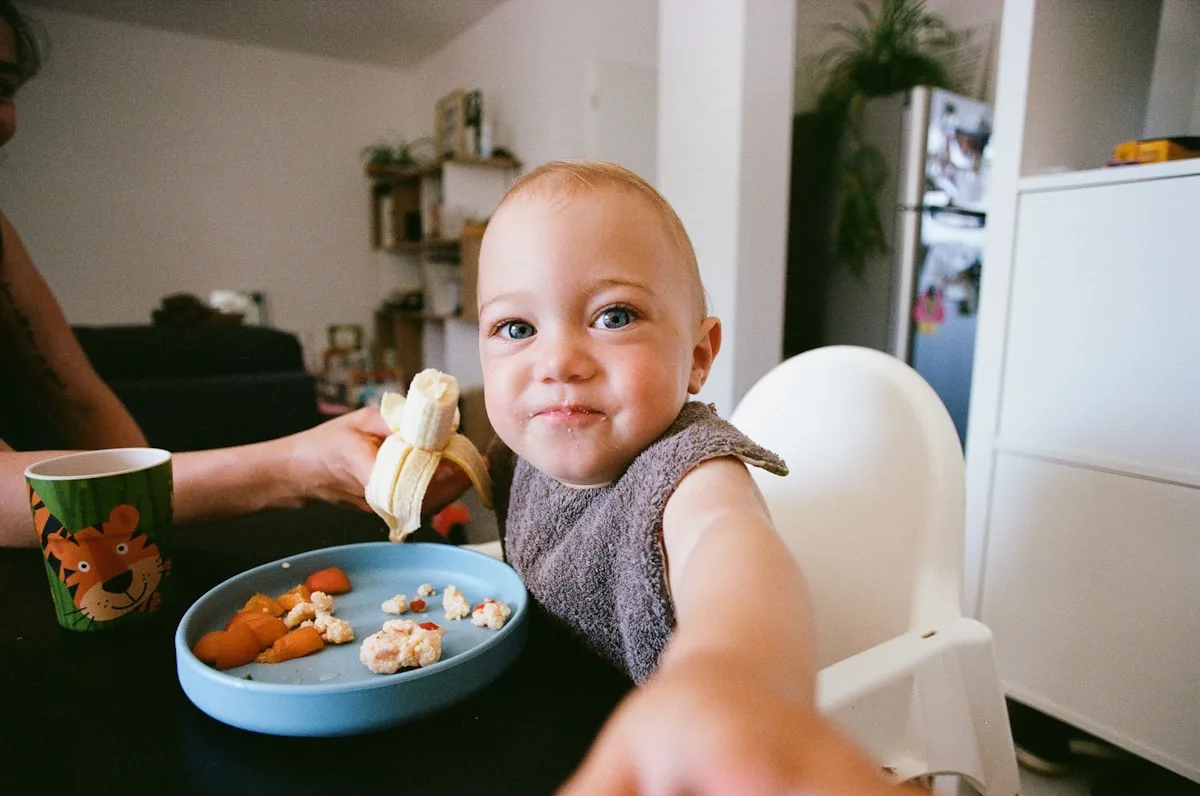 Dítě při jídle s talířem zdravé stravy obsahující olivový olej